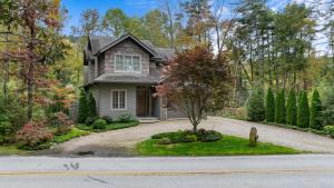 una casa con un albero in mezzo a un vialetto di Dancing Bear Walk to Town a Highlands