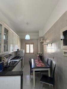 una cucina con tavolo, lavandino e tavolo di Domus Poppea - a 5 minuti da Pompei e parcheggio gratuito a Torre Annunziata