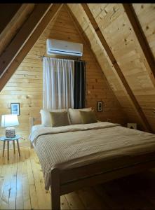 a bedroom with a large bed in a attic at Nadiaa Wood House in Ilidza