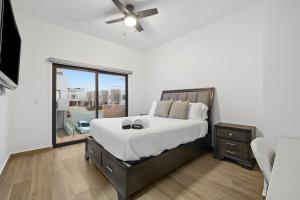 a bedroom with a bed with a ceiling fan and a window at Playas de Tijuana in Tijuana