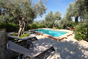 a swimming pool with two chairs and a table and a table and chairs at Casa Eva in Fornalutx +11 photos