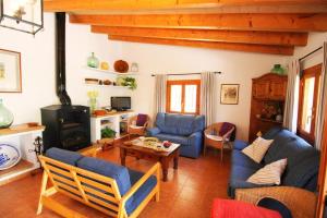 a living room with blue couches and a wood stove at Casa Eva in Fornalutx