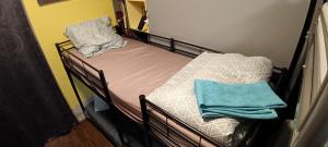 a metal bunk bed with blue towels on it at Lit en dortoir pour homme chez l'habitant au Kremlin-Bicêtre in Le Kremlin-Bicêtre
