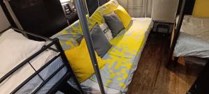 a bedroom with two bunk beds with yellow pillows at Lit en dortoir pour homme chez l'habitant au Kremlin-Bicêtre in Le Kremlin-Bicêtre