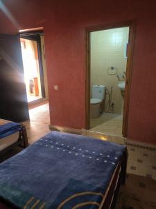ein Schlafzimmer mit einem Bett und ein Badezimmer mit einer Toilette in der Unterkunft Jad Auberge in Ourika