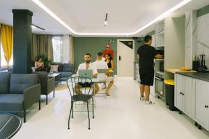 a group of people in a living room with a kitchen at U-nit Hostel Central Park in Valencia