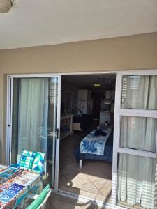 Habitación con vistas a un dormitorio con cama y balcón. en langstrand apartment retreat !, en Langstrand