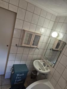 Un baño con lavabo, inodoro y espejo. en langstrand apartment retreat !, en Langstrand 6 fotos más