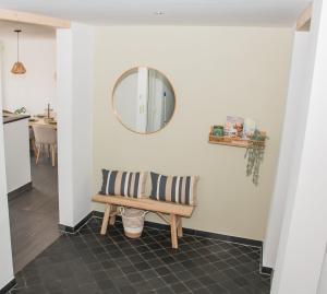 a mirror on a wall above a bench in a hallway at Green& Light House16 in Kettenis +19 photos