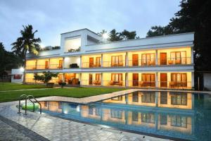 ein großes Haus mit einem davorliegenden Swimmingpool in der Unterkunft POP 84102D Travancore Island Resort in Tiruvallam + 26 Fotos