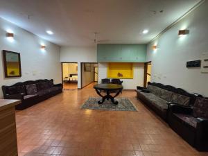 ein Wohnzimmer mit Sofas und einem Tisch. in der Unterkunft POP 84102D Travancore Island Resort in Tiruvallam