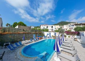a swimming pool with lounge chairs and umbrellas at Charme Hotel La Villa Tina in Ischia