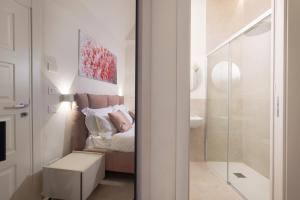 a bedroom with a bed and a bathroom with a shower at B&B IL MORO Boutique Rooms in Siena