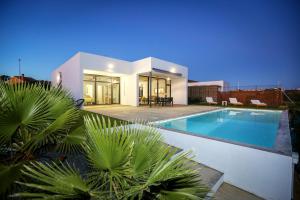 a house with a swimming pool in front of it at Villa Guadiana Golf 2 in Ayamonte