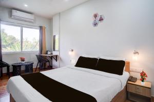 a bedroom with a large white bed and a window at Super Townhouse Lalmati National Highway 27 Formerly The Pinnacle Inn in Dispur