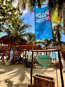 a sign on a beach with a table and chairs at Aquarius Diving Club y Cabañas in Rincón