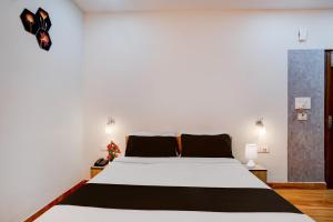 a bedroom with a large bed with white sheets at Super Townhouse Lalmati National Highway 27 Formerly The Pinnacle Inn in Dispur