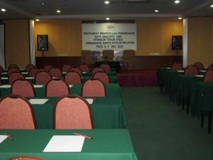 a conference room with green tables and chairs and a screen at Hotel Seri Malaysia Genting Highlands in Genting Highlands