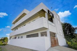 Hotel O Royal Care Hospital Coimbatore Formerly Haven Stays في Irugūr: مبنى ابيض عليه لافته