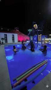 a group of people sitting in a swimming pool at night at شاليه جوري حتا-4-Chalet Jory Hatta in Būbādī +29 photos