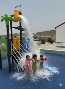 two girls are playing in a water park at شاليه جوري حتا-4-Chalet Jory Hatta in Būbādī
