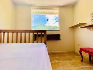 a bedroom with a bed and a window at Casa do Sol, Pássaros e Montanhas em Ubatuba Barra Seca in Ubatuba