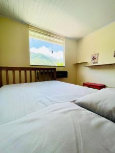 a bedroom with two white beds and a window at Casa do Sol, Pássaros e Montanhas em Ubatuba Barra Seca in Ubatuba