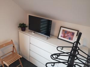 a living room with a tv on a dresser at Dom z widokiem na góry in Zawodzie
