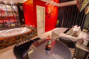 a room with a tub and a table and a bed at Hotel Motel Paradiso - Tapera-RS in Tapera
