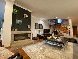 a living room with a fireplace and a staircase at Camélias Casa de Charme in Varziela
