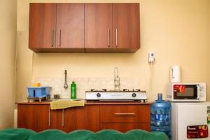 una cucina con mobili in legno e un forno a piano cottura di Breeze Land a Ruaka Altre 14 foto