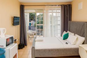 a bedroom with a bed and a tv and a window at Breeze Land in Ruaka
