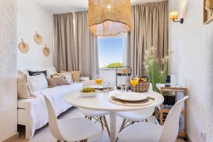 a living room with a white table and chairs at Manelinha Apartment - cozy apartment with pool and beach in Quarteira