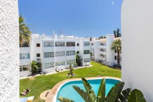 an apartment with a swimming pool and a building at Manelinha Apartment - cozy apartment with pool and beach in Quarteira
