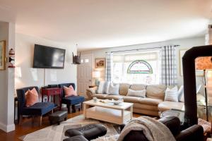 a living room with a couch and a table at 5 Min to Beach Yard w Fire Pit in Wellfleet +30 photos