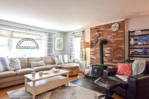 ein Wohnzimmer mit einer Couch und einer Ziegelwand in der Unterkunft 5 Min to Beach Yard w Fire Pit in Wellfleet