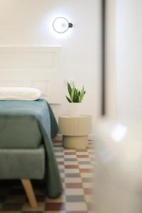 Un dormitorio con una cama y una planta en maceta. en Pepenero Apulian Rooms, en Noci