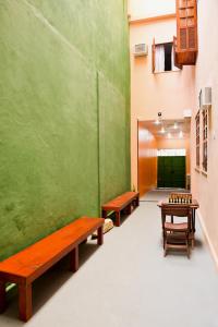 2 bancos en una habitación con una pared verde en Orange - Casa de Hóspedes - modelo Pousada, en Río de Janeiro