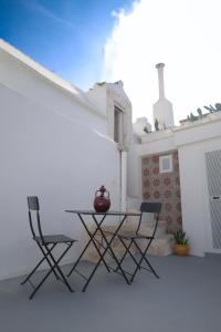 un patio con mesa y 2 sillas en Pepenero Apulian Rooms, en Noci