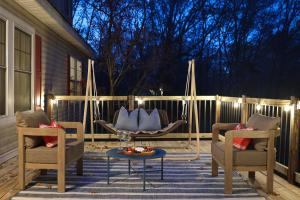 Pine & Paddle Getaway Game Room Hot Tub Pool في مسكيغون: فناء مع كرسيين وطاولة وأرجوحة +74 صورة