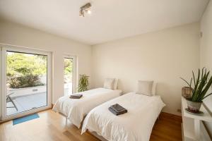 a bedroom with two beds and a large window at Bafureira 22 Rooftop in Parede +92 photos