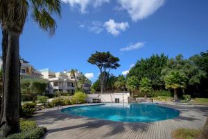 a swimming pool in a yard with palm trees at Bafureira 22 Rooftop in Parede