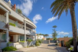 an exterior view of a building with a palm tree at Bafureira 22 Rooftop in Parede