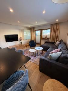 a living room with a couch and a table at Sonnhang Apartment Unterkofler in Sankt Johann im Pongau