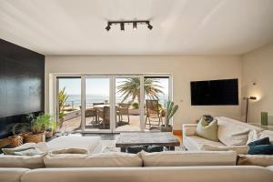 a living room with couches and a television and a table at Bafureira 22 Rooftop in Parede