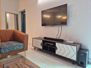 a living room with a couch and a television on a wall at The Palm Villa in Jaipur
