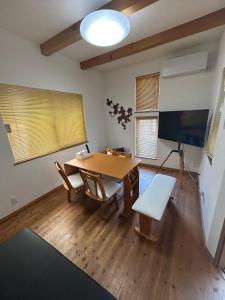 青森グッドタイム旭町的带桌子和电视的餐厅