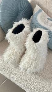 two white furry pillows sitting on a couch at Molfar in Yasinya