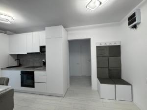 a kitchen with white cabinets and a counter top at Panoramic SkyView Apartment in Petroşani