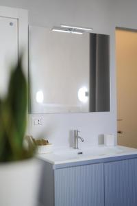 Un baño con un lavabo blanco y un espejo. en Pepenero Apulian Rooms, en Noci 10 fotos más